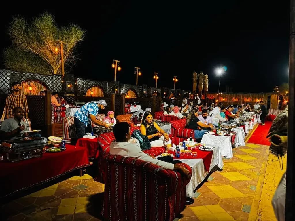Guests having dinner at the desert camp after dark